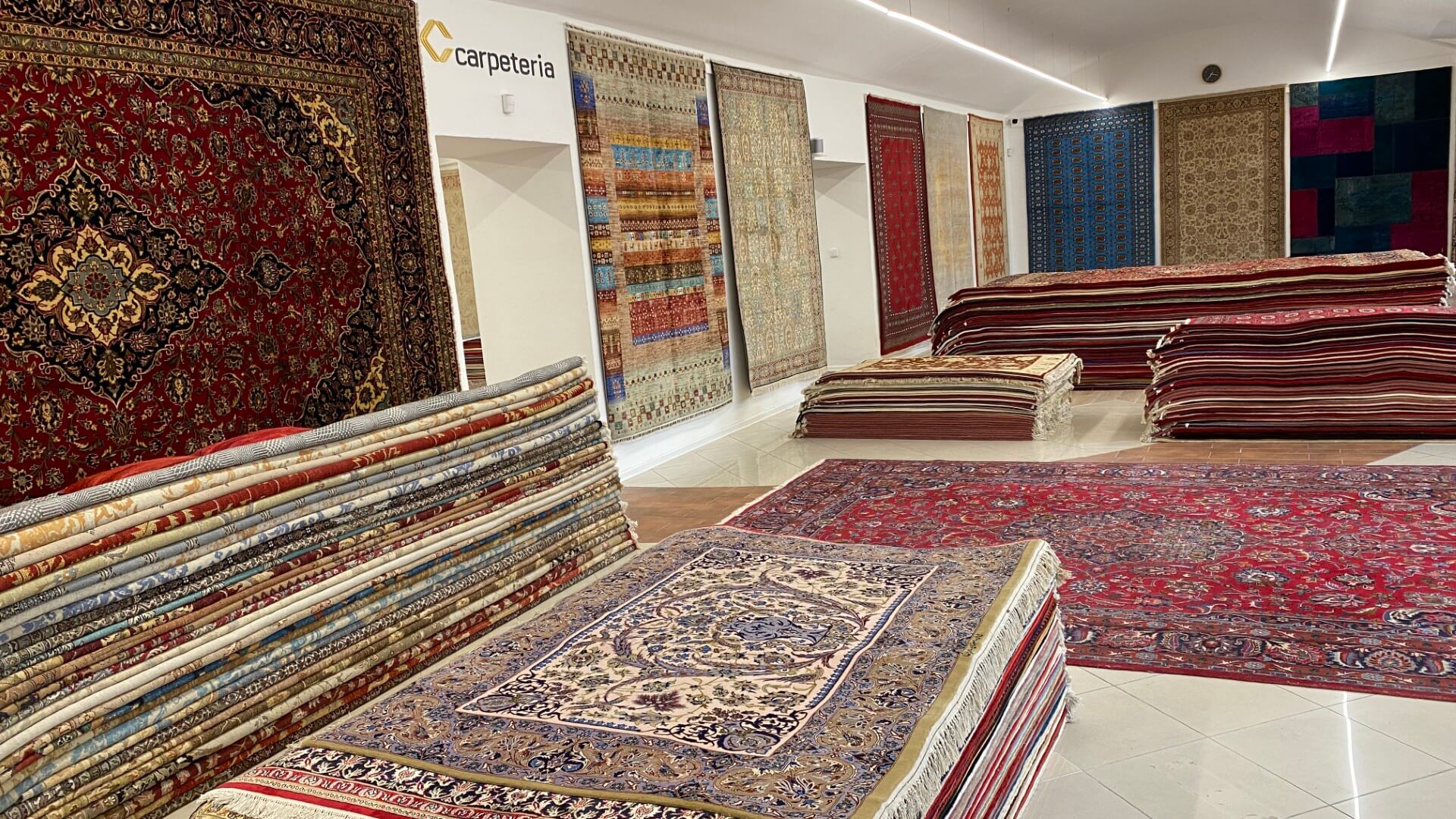Reihen handgeknüpfter Teppiche, die im Ausstellungsraum ausgebreitet und verglichen werden können